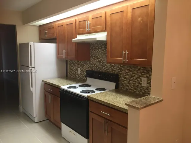 a kitchen with stainless steel appliances granite countertop a refrigerator and a stove