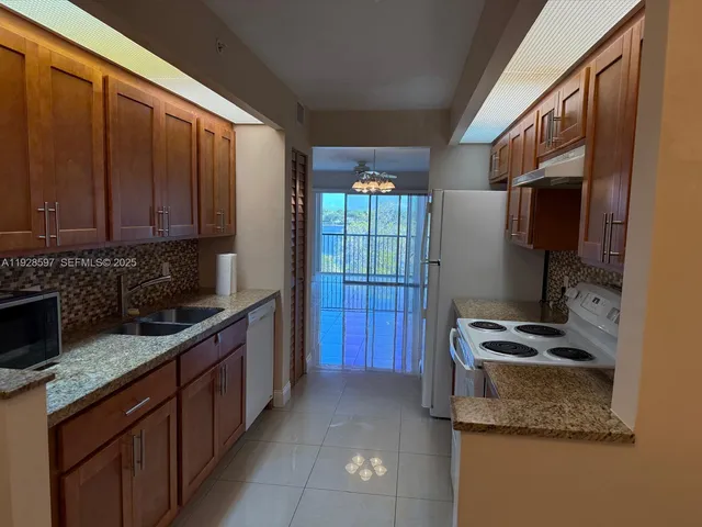 a kitchen with stainless steel appliances granite countertop a stove a sink and a refrigerator