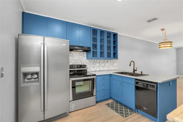 a kitchen with stainless steel appliances granite countertop a sink stove and refrigerator