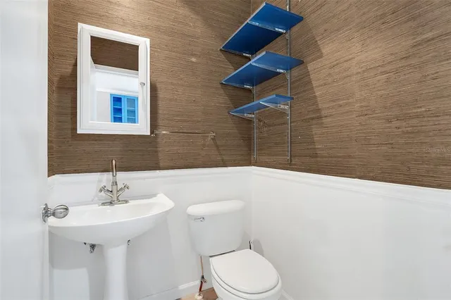 a bathroom with a sink a toilet and mirror