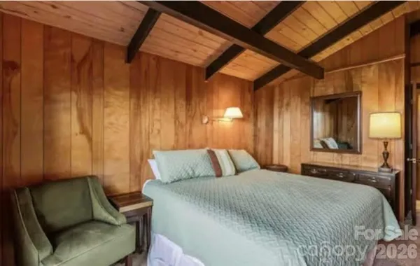 a large bed sitting in a bedroom next to a window