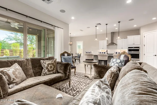 a living room with furniture kitchen and a large window