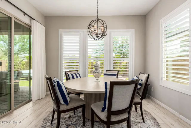 a dining room with furniture a chandelier and wooden floor