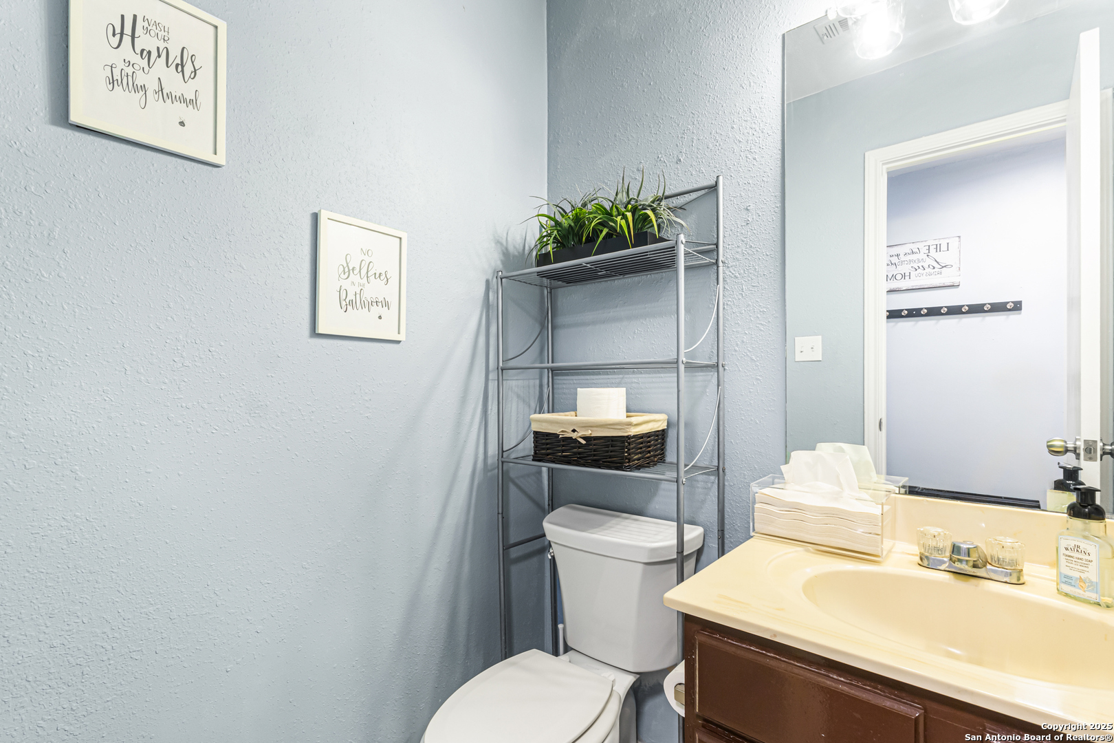 5617 Timber Rain San Antonio, TX 78250 - Photo 15 of 32 a white toilet sitting next to a bathroom sink