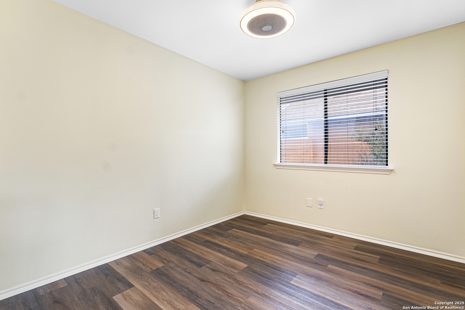 5617 Timber Rain San Antonio, TX 78250 - Photo 24 of 32 an empty room with wooden floor and windows