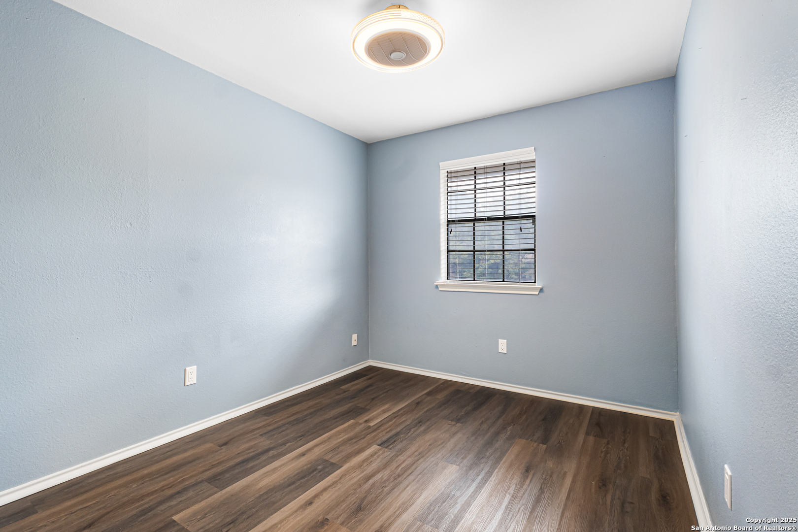5617 Timber Rain San Antonio, TX 78250 - Photo 26 of 32 an empty room with wooden floor and windows