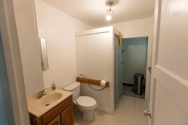 a bathroom with a sink a toilet and shower