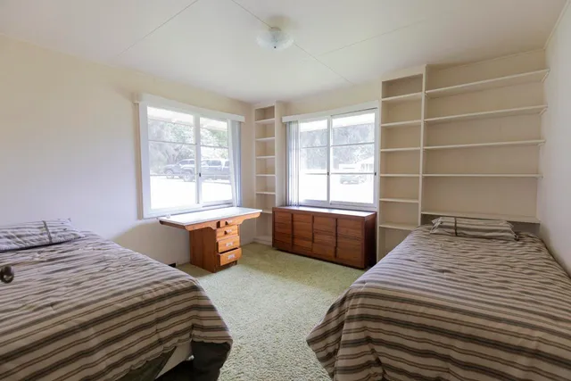 a bedroom with a bed and a large window