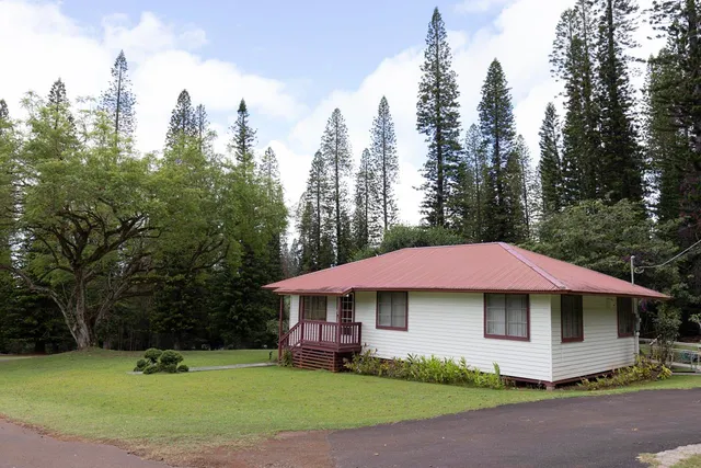 a yellow house with trees in front of it