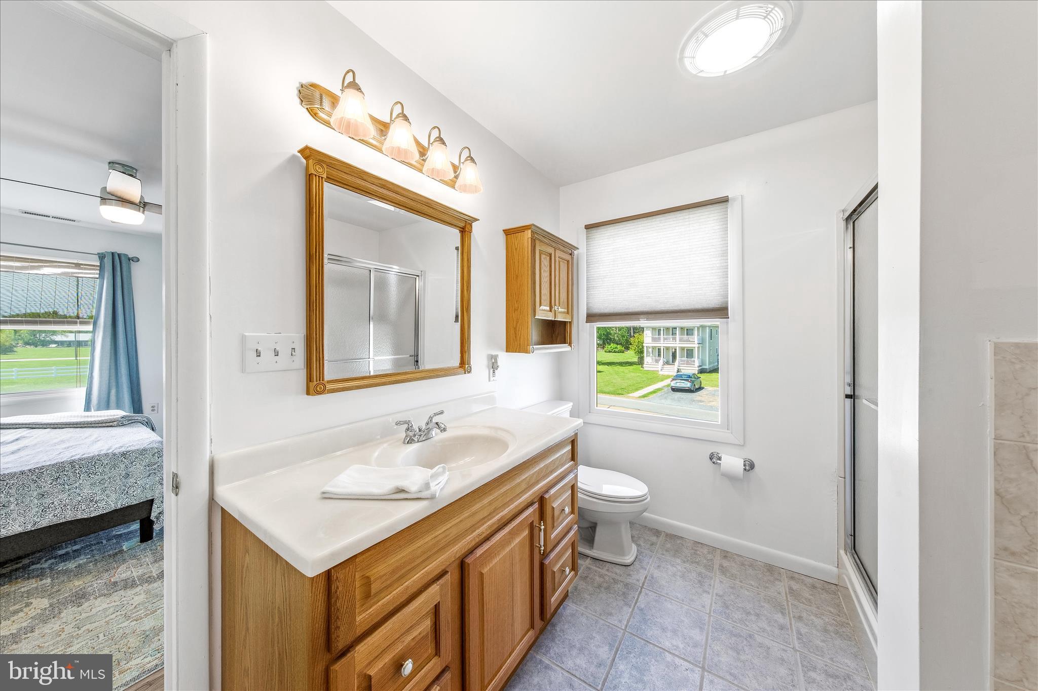 21406 Dogwood Cove Road Tilghman, MD 21671 - Photo 43 of 68 a bathroom with a sink toilet double vanity and window