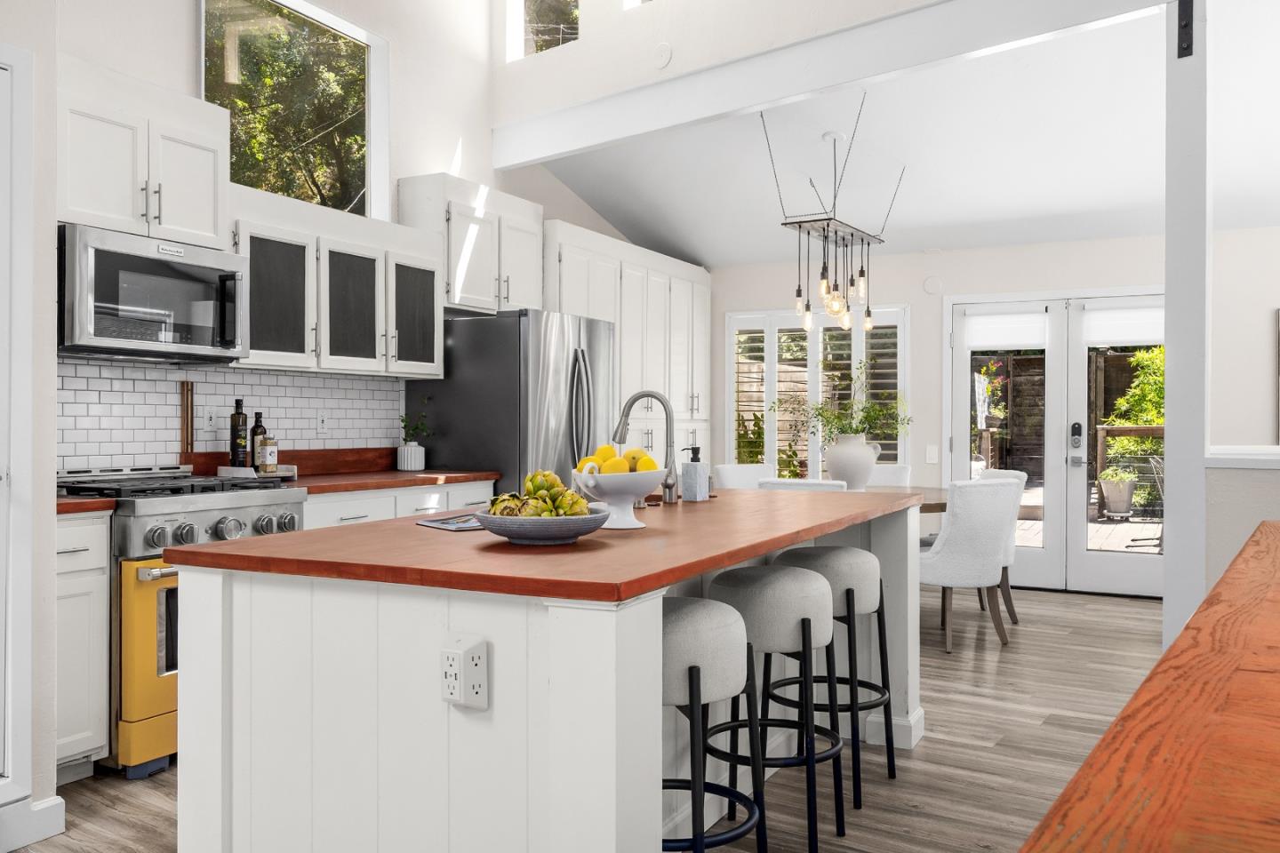 321 Valencia Road Aptos, CA 95003 - Photo 4 of 50 a kitchen with stainless steel appliances granite countertop a stove a refrigerator a kitchen island a dining table and chairs with wooden floor