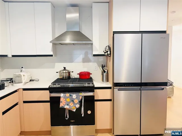 a kitchen with stainless steel appliances granite countertop a refrigerator and a stove