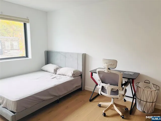 a bedroom with a bed a chair and a window