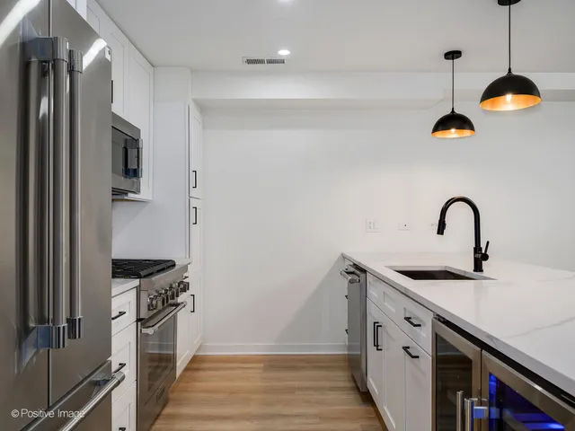a kitchen with stainless steel appliances granite countertop a sink and a refrigerator
