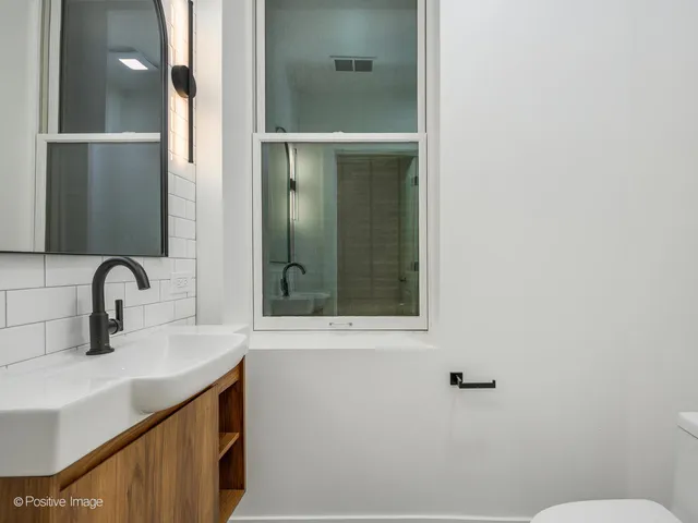 a bathroom with a sink and mirror with toilet