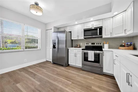 a kitchen with stainless steel appliances granite countertop a stove a microwave and a refrigerator