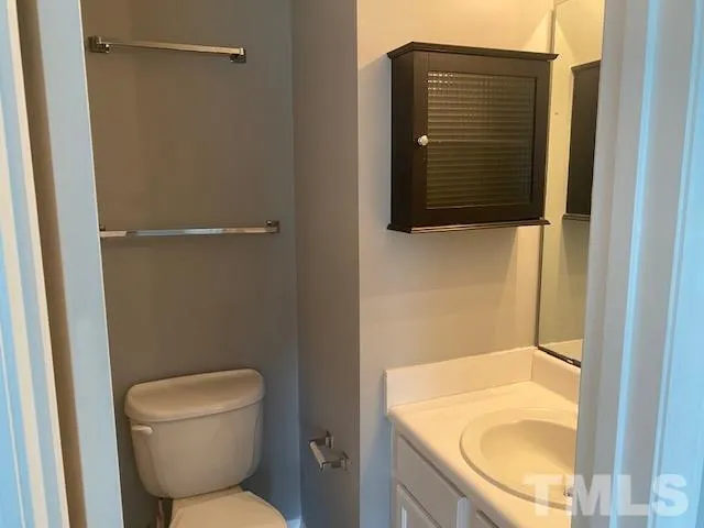 a bathroom with a granite countertop toilet and a sink