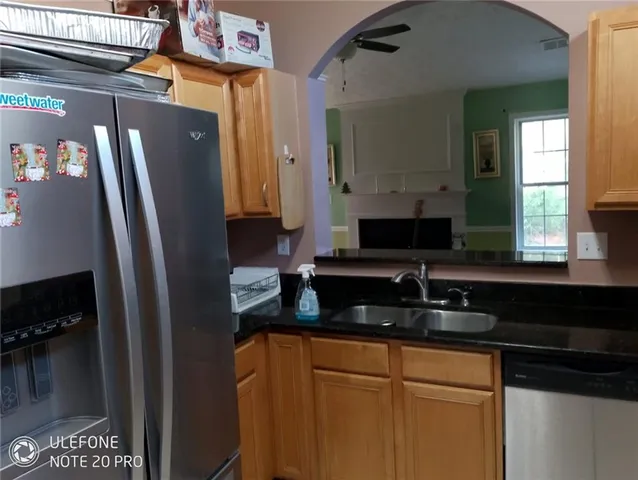a kitchen with granite countertop white cabinets stainless steel appliances and a sink
