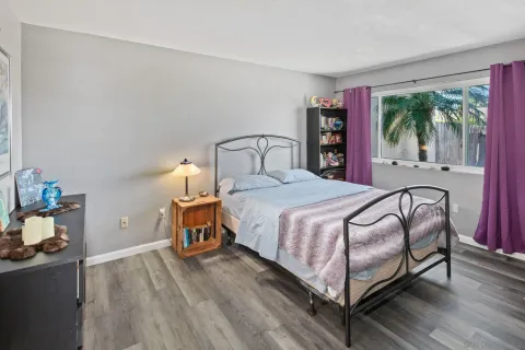 a bedroom with a bed and large windows