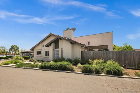a front view of a house with plants and trees