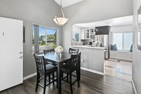 a view of a dining room and livingroom with furniture wooden floor a rug a chandelier