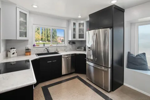 a kitchen with a refrigerator sink and cabinets