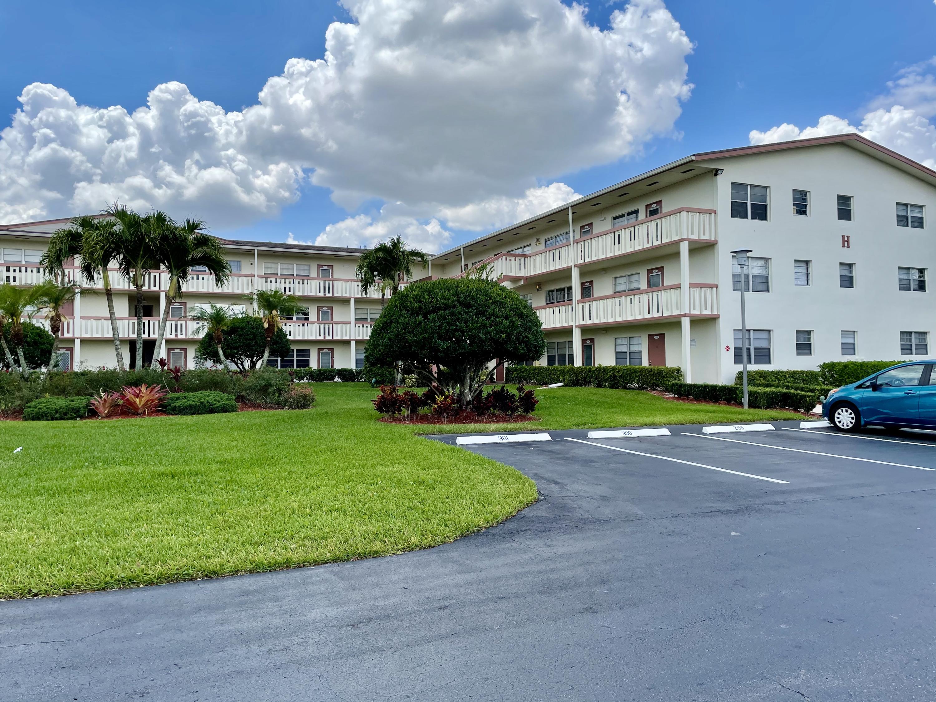 a view of a big building with a big yard and large trees