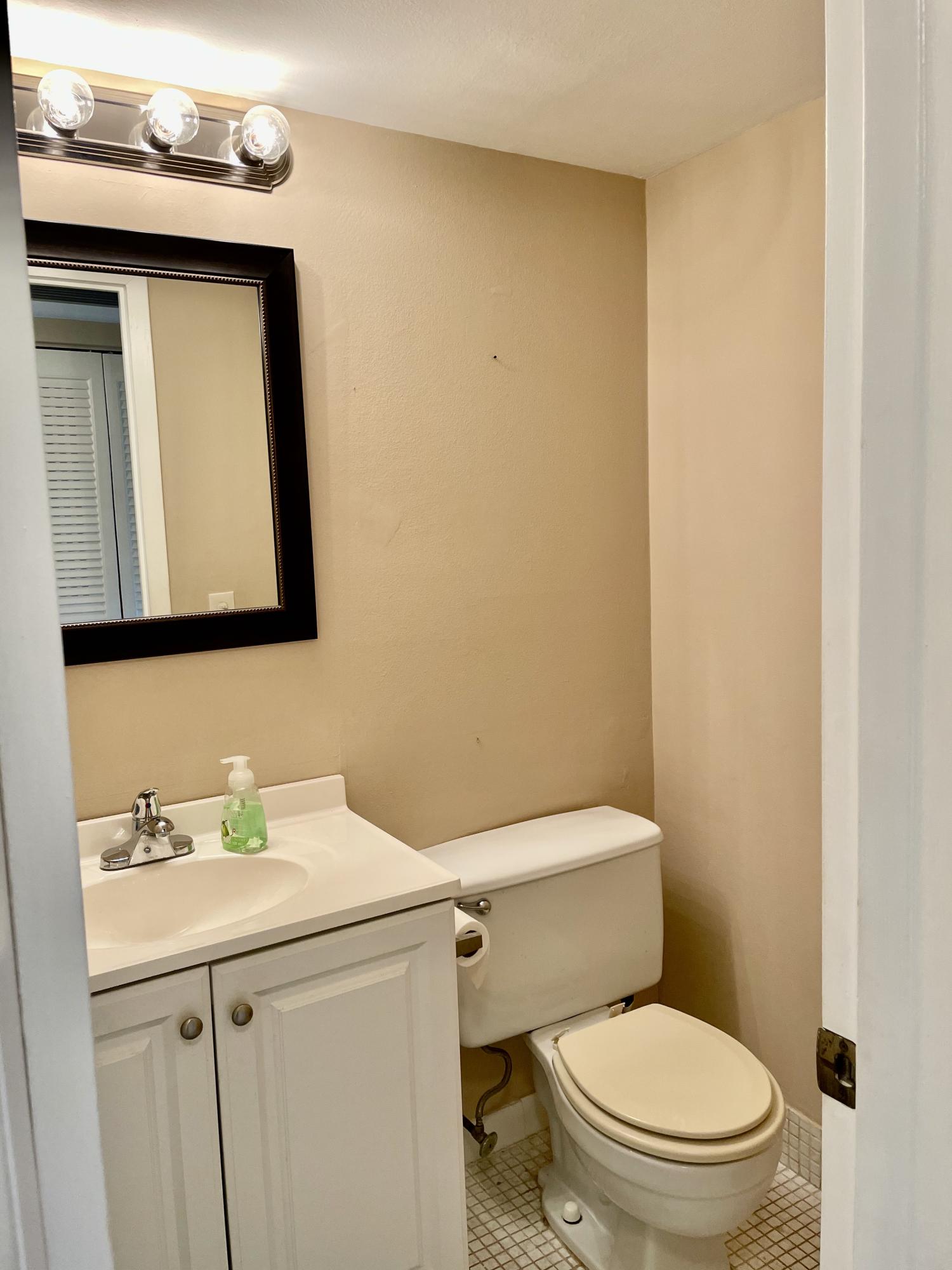 296 Preston H Boca Raton, FL 33434 - Photo 14 of 21 a bathroom with a toilet sink and mirror