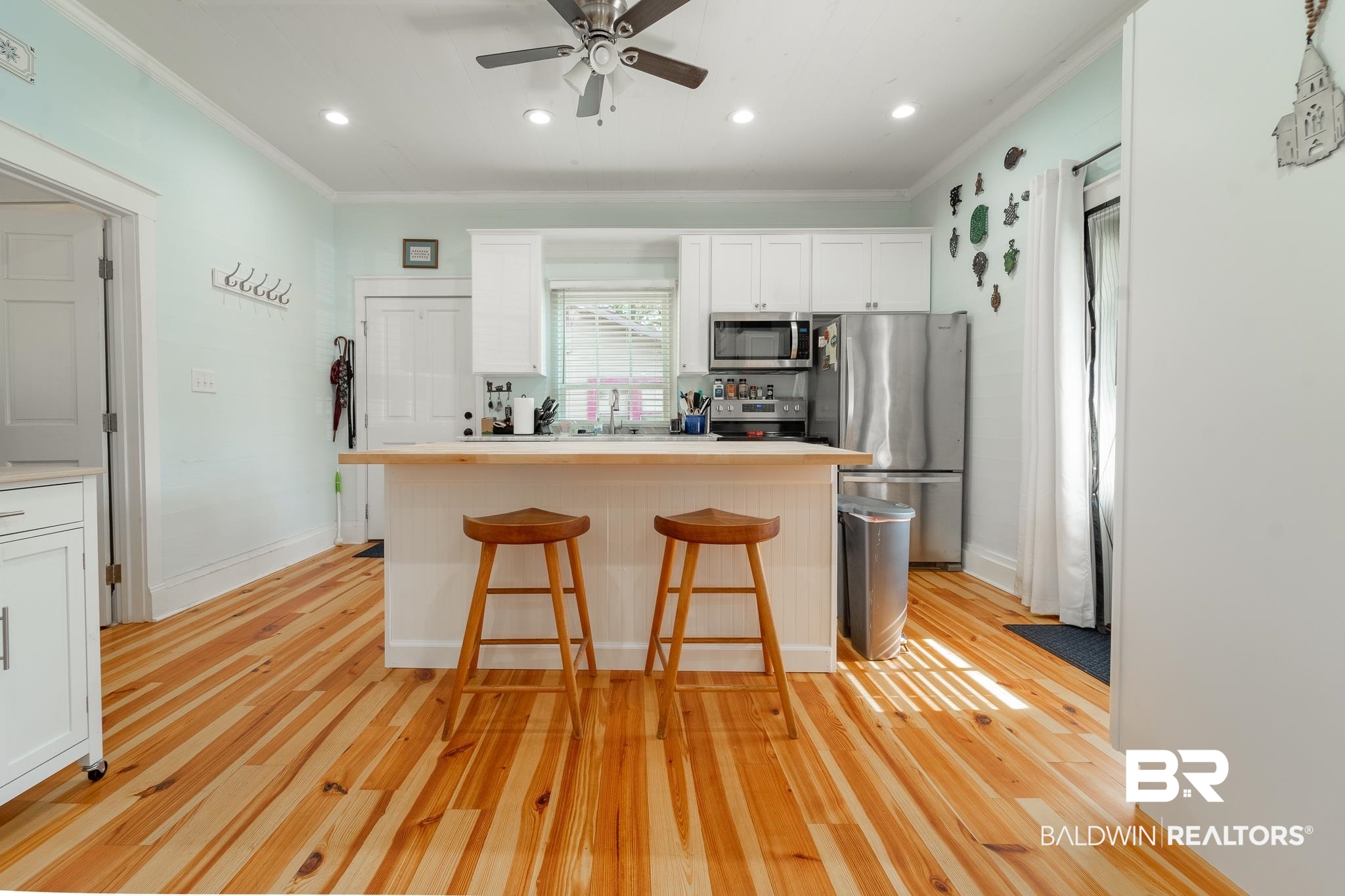 950 Texas Street Mobile, AL 36604 - Photo 6 of 17 Kitchen with appliances with stainless steel finishes, light hardwood / wood-style floors, a kitchen bar, white cabinets, and ceiling fan
