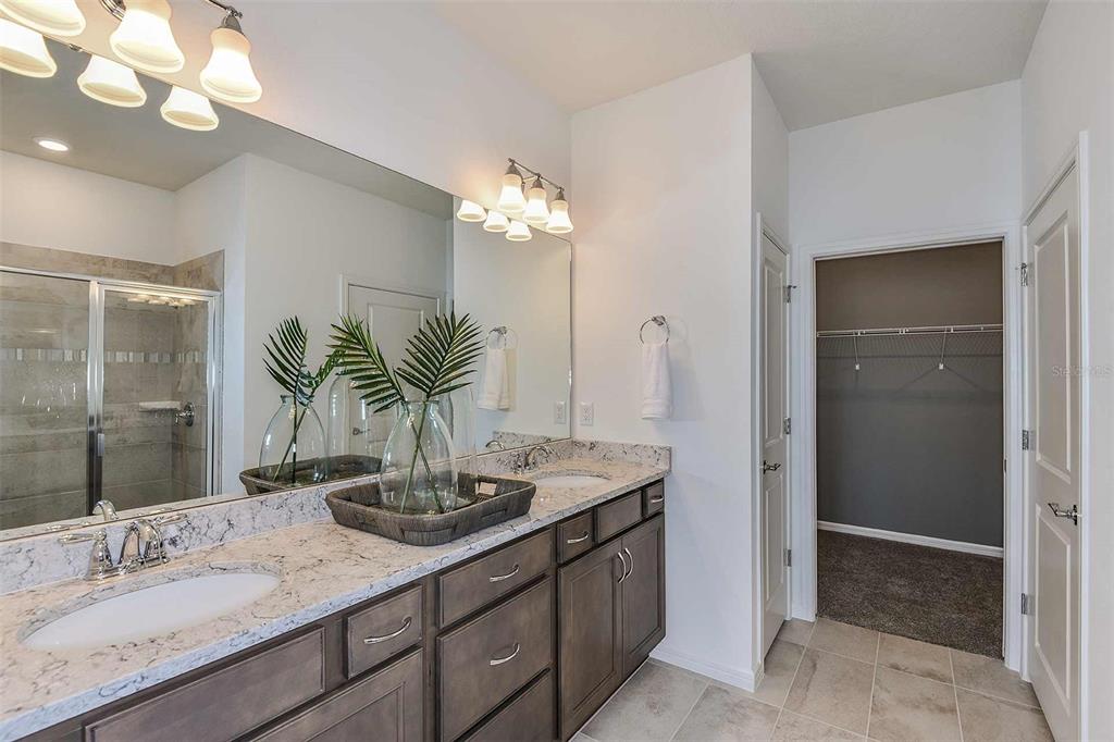 2362 Daisy Tree Road St. Cloud, FL 34771 - Photo 20 of 31 a bathroom with a granite countertop sink a large mirror and a shower