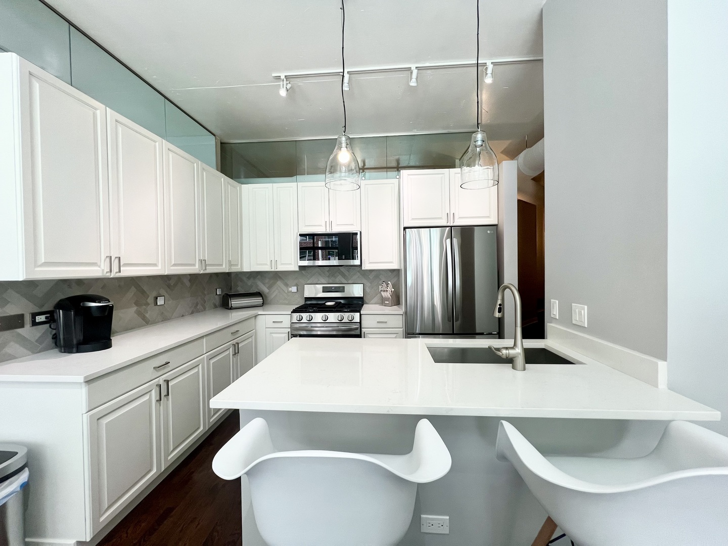 910 West Madison Street, Unit 602 Chicago, IL 60607 - Photo 2 of 14 a kitchen with stainless steel appliances a sink a stove a refrigerator a center island and cabinets