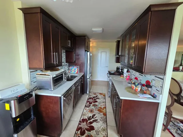 a kitchen with stainless steel appliances granite countertop a refrigerator and a stove top oven