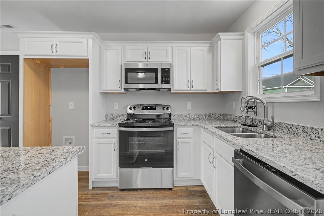 214 Lee Street Spring Lake, NC 28390 - Photo 21 of 44 a kitchen with stainless steel appliances granite countertop a sink stove and microwave