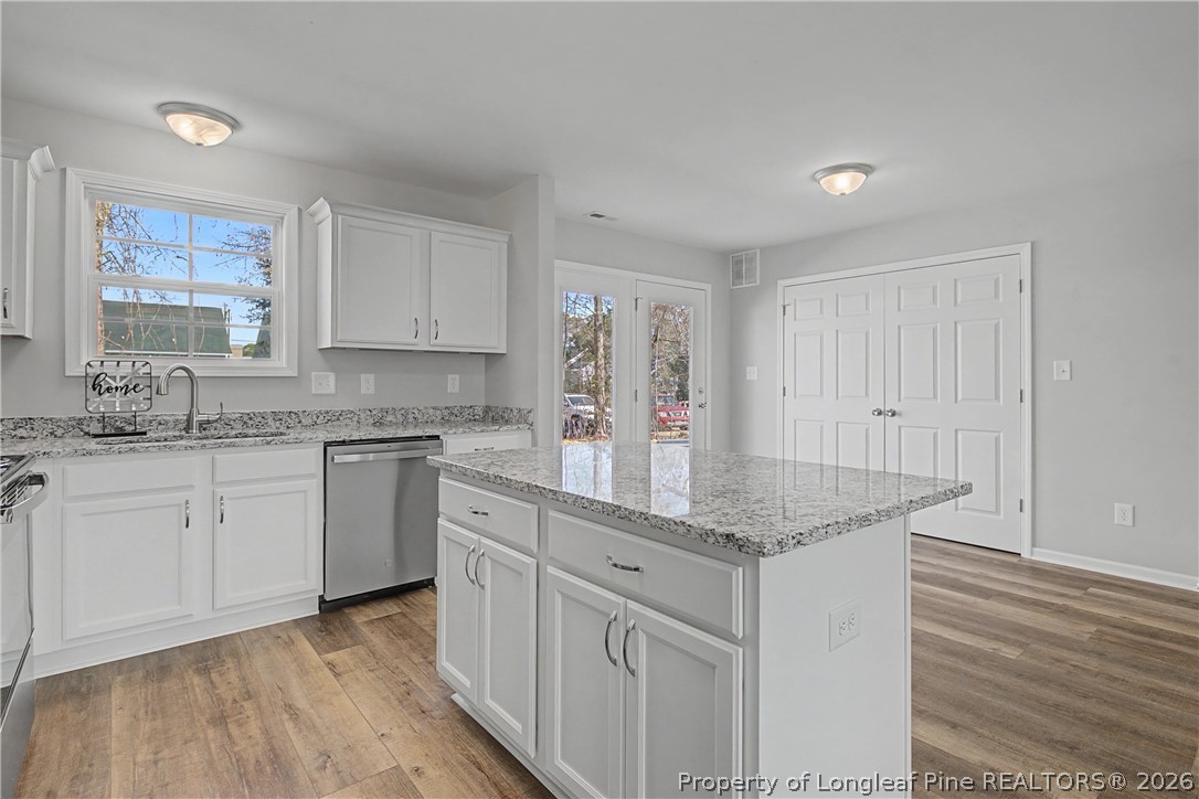 214 Lee Street Spring Lake, NC 28390 - Photo 24 of 44 a kitchen with granite countertop white cabinets and white appliances