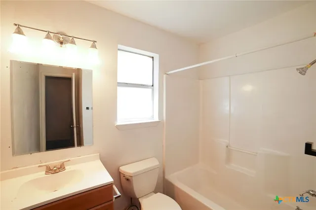 a bathroom with a sink mirror vanity and toilet