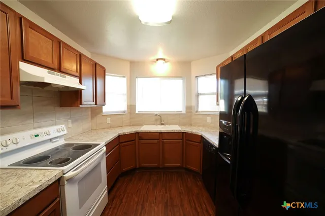 a kitchen with a sink dishwasher a stove and a refrigerator