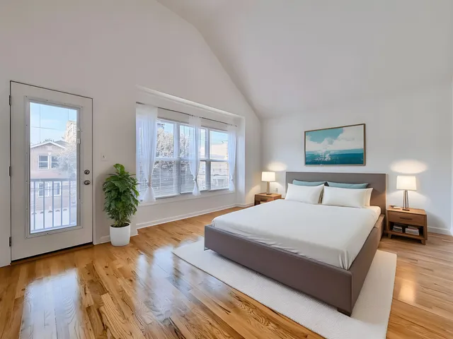 a spacious bedroom with a large bed a chandelier and windows
