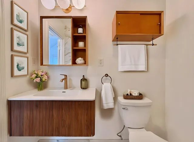 a bathroom with a sink mirror and toilet