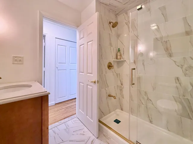 a bathroom with a sink a toilet and shower