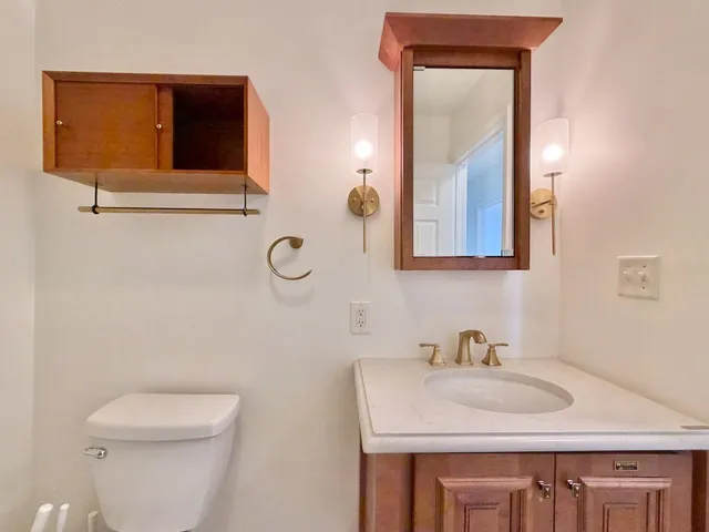 a bathroom with a toilet sink and mirror