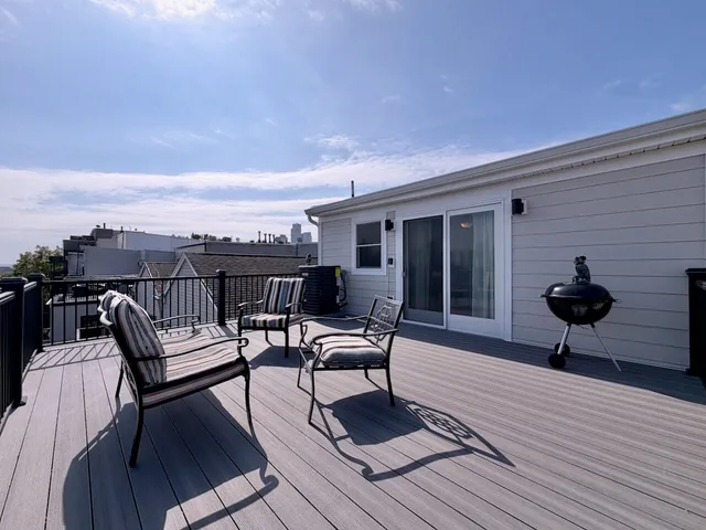 a view of a roof deck with chair and wooden floor