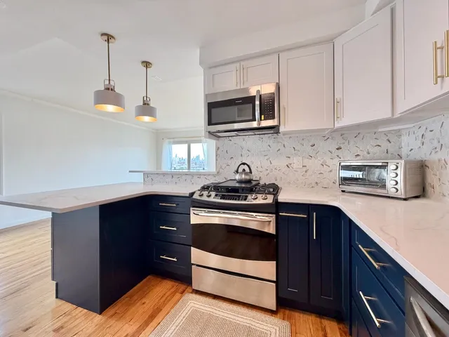 a kitchen with stainless steel appliances a sink a stove and microwave