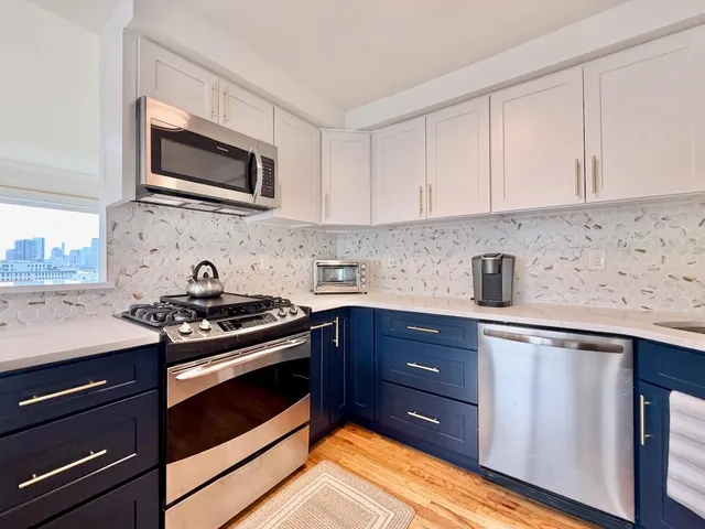 a kitchen with stainless steel appliances granite countertop a stove and a microwave