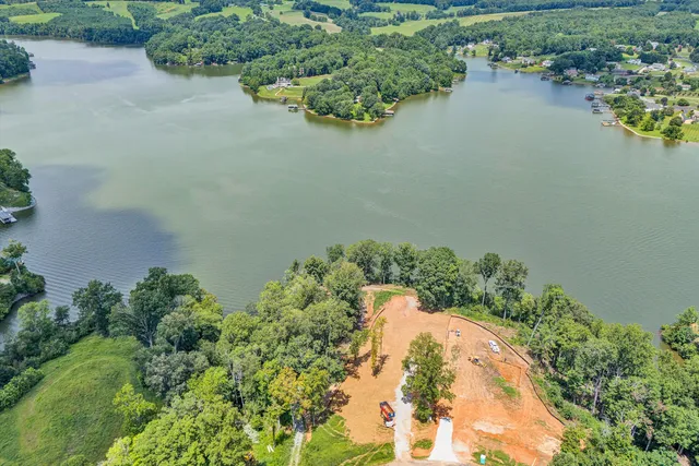 an aerial view of a house with a yard and lake view