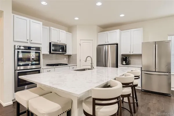 a kitchen with stainless steel appliances a refrigerator stove microwave and cabinets