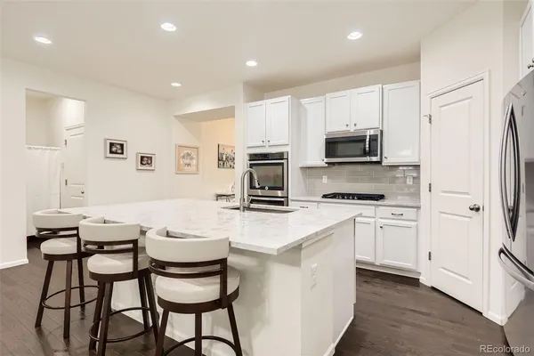 a kitchen with stainless steel appliances a stove a sink refrigerator and a microwave