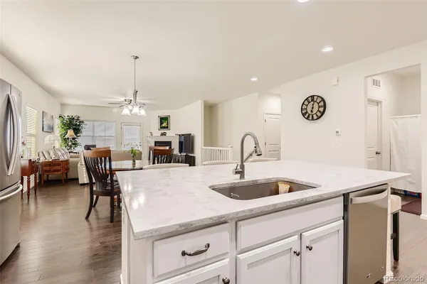 a kitchen with stainless steel appliances granite countertop a sink a stove and a wooden floors