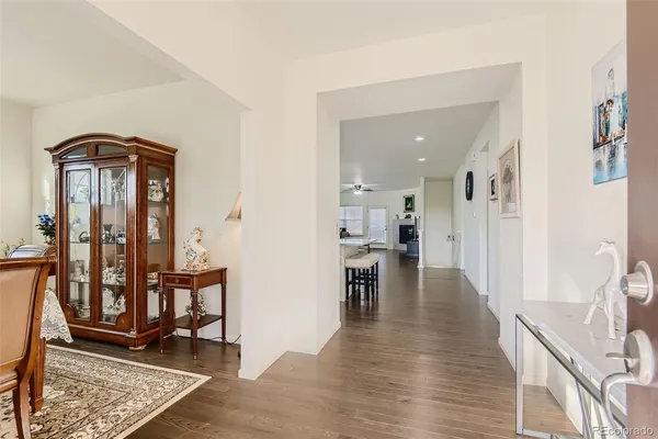 a view of a hallway with wooden floor windows and a living room