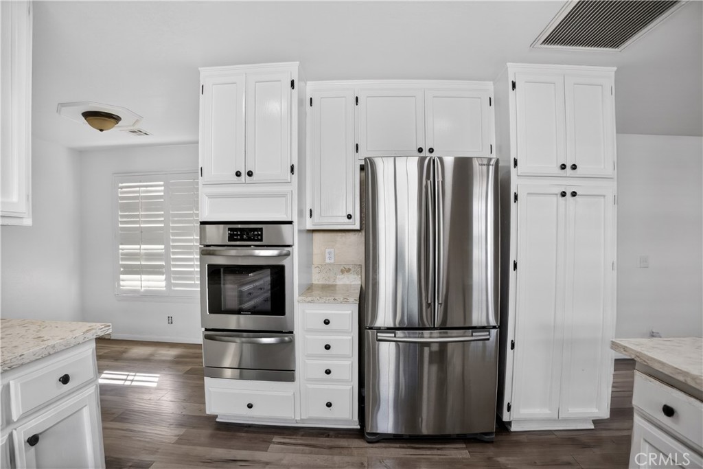 43631 37th Street West Lancaster, CA 93536 - Photo 12 of 38 a kitchen with stainless steel appliances a refrigerator stove and cabinets