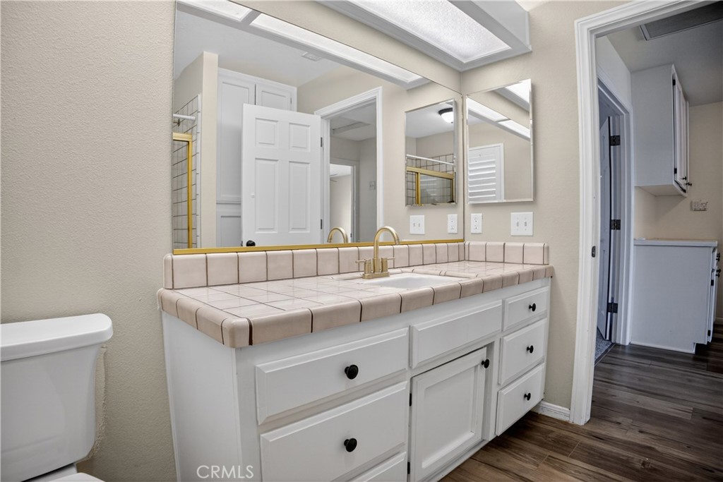 43631 37th Street West Lancaster, CA 93536 - Photo 23 of 38 a bathroom with a granite countertop sink a toilet and a mirror